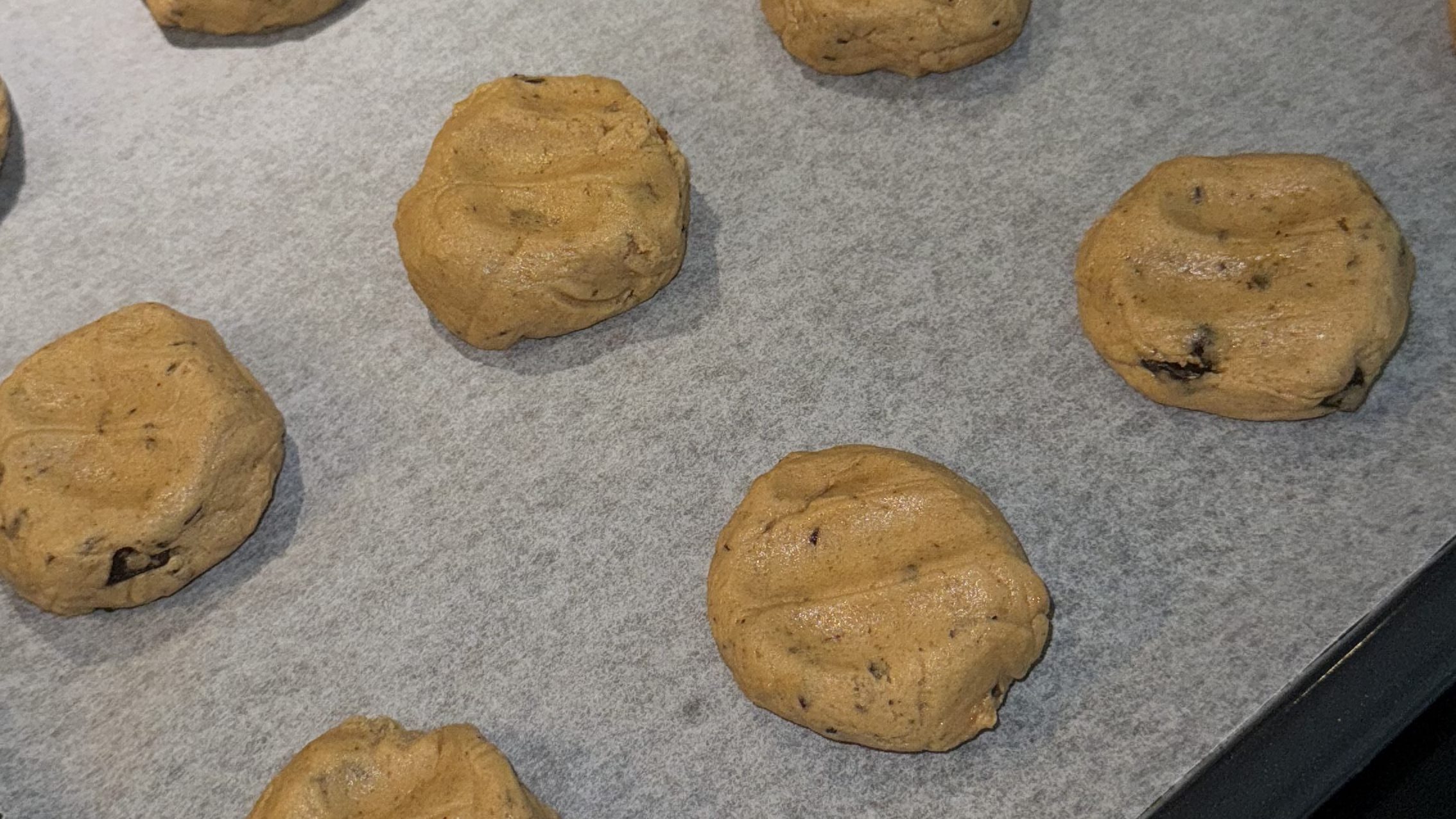 Raw chocolate chip cookie dough on a baking tray